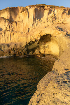 White trachyte rocks and turquoise sea at Cane Malu beach, Bosa, Sardinia, Italy.