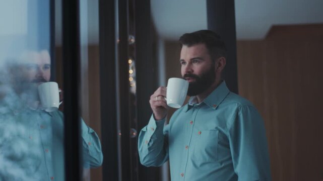 Reflective man during work respite inside, Contemplative individual enjoying peaceful break at office window