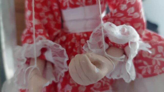 Detailed view of a czech traditional marionette doll in red dress with strings