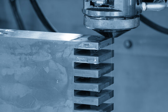 Close-up of a high-precision Wire EDM cutting process on a metal workpiece in a smart factory environment.