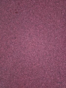 close up texture of red rubber running track surface used for athletics and outdoor sports field