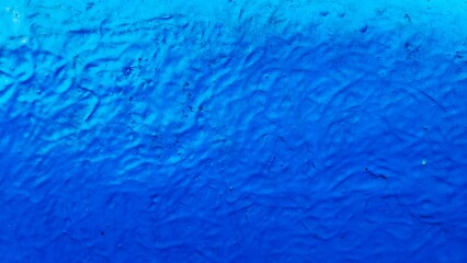 Textured blue paint surface. Abstract wavy wall background. Vibrant azure plaster finish. Modern indigo artistic texture. Bright blue architectural backdrop.