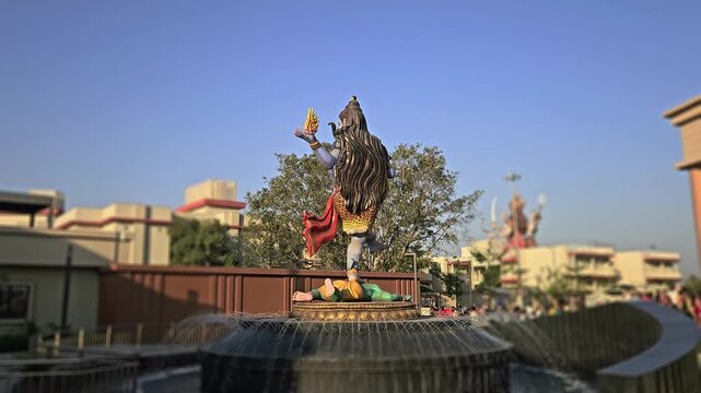 Statue of Lord Shiva in Nataraja Tandava dance pose at Char Dham Temple in Vrindavan, India. The scene represents cosmic creation, destruction, and divine energy in Hinduism. Surrounded by a fountain