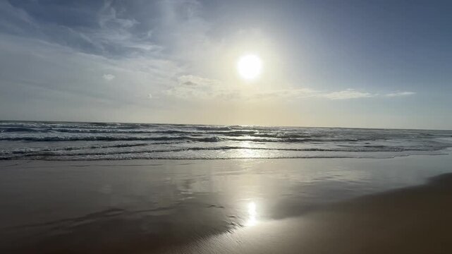 Shimmering seawater with bright sun reflection and soft waves at Lido Marinella coast, Sicily, Italy.