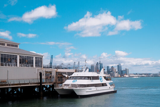 Devonport, Auckland: A white passenger ferry docked at the historic Devonport terminal pier with the city skyline in the distance