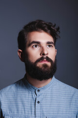 Obraz premium Portrait of a thoughtful young bearded man looking away from the camera.