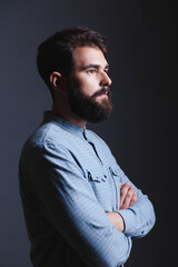 Fototapeta premium Side profile portrait of a handsome bearded man in a blue shirt.