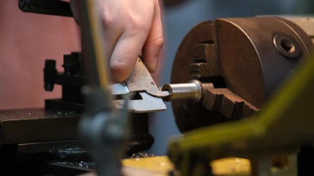 A close-up of a metalworking machine with a metal rod being machined