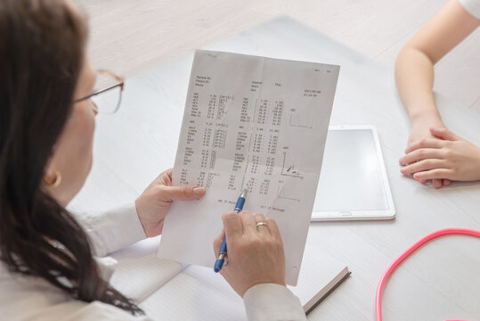 doctor explaining medical report to patient during consultation representing diagnosis, healthcare communication and clinical analysis
