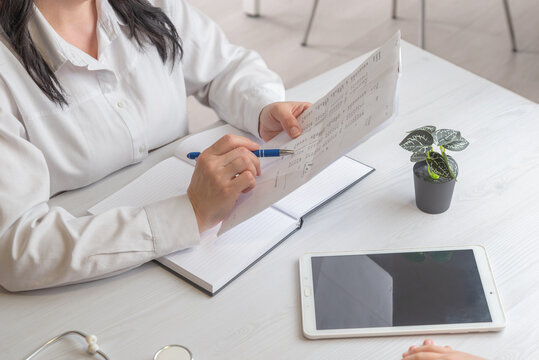 doctor reviewing medical report with tablet on desk representing healthcare analytics and digital medical workflow
