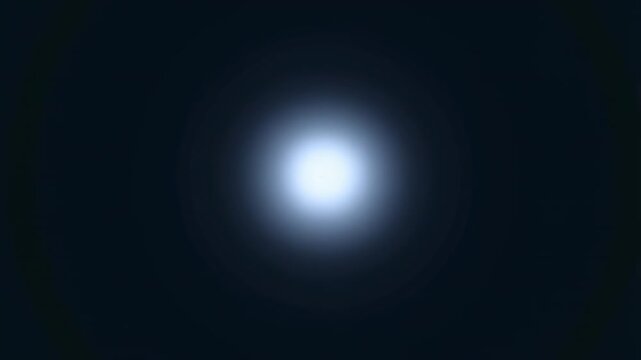 Slow zoom tracking shot toward glowing orb of light expanding in dark space with soft halo and atmospheric haze