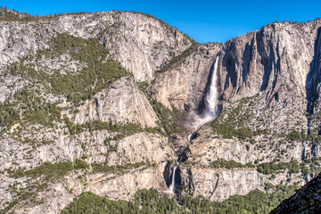 Grand canyon waterfall cascades through towering rock faces © ExploringandLiving