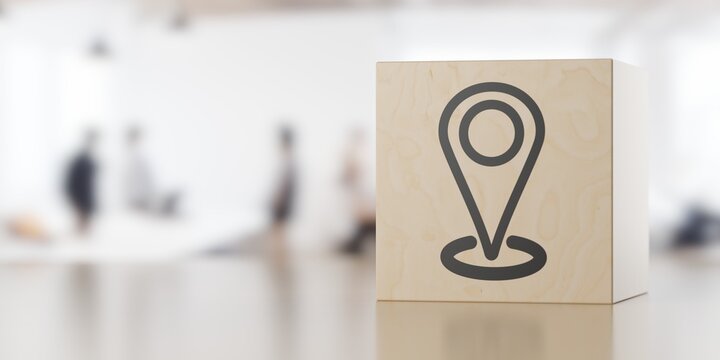 Location marker icon on wooden block on table with office background, contact or adress business concept