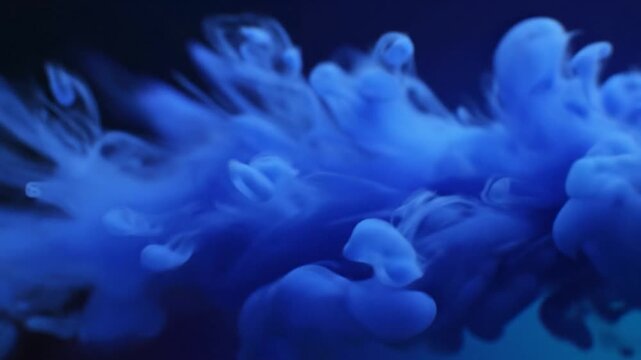 Blue smoke cloud in dark background.