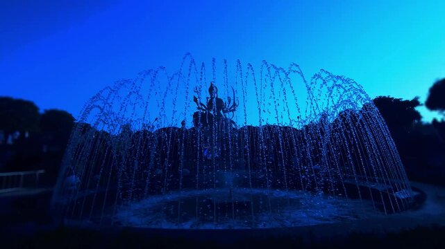 Silhouette of Goddess Durga statue behind water fountain at sunset in India. Dramatic spiritual scene with flowing water, golden sky, and temple ambiance, Chaar Dham Temple in Vrindavan, Uttar Pradesh
