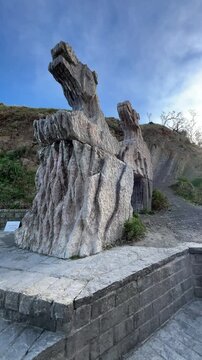 Eye-level view of flysch stone sculpture at Itzurun Beach entrance