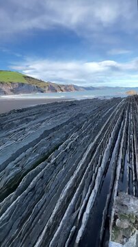 Eye-level view of Itzurun flysch shoreline with beach and sea