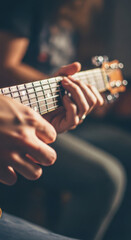 Fototapeta premium Close-Up of Musician's Hands Playing Chords on Acoustic Guitar Fretboard