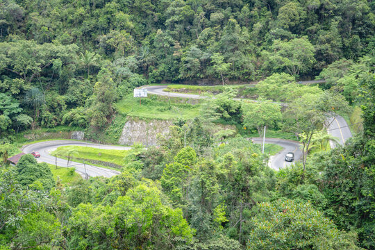 Winding Kelok 9 mountain road surrounded by lush tropical forest in West Sumatra, Indonesia, showcasing iconic curves, scenic landscape, and transportation route.