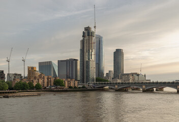 Obraz premium As the evening light softens into a hazy gold, the Blackfriars skyline reveals a city in a constant state of rebirth. The slender, curved silhouette of One Blackfriars often called 'The Vase' glimmers
