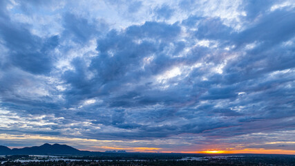 A breathtaking aerial view of Khone Phapheng Waterfall at sunset reveals powerful multi tiered cascades surging through rocky channels, glowing beneath golden light in southern Laos. © Narong Niemhom