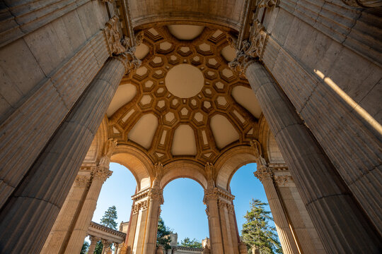A dramatic low-angle perspective showcases the towering Greco-Roman columns and intricate rotunda of the Palace of Fine Arts against a brilliant blue San Francisco sky.