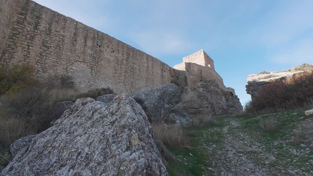 Medieval castle walls and tower on rocky cliff