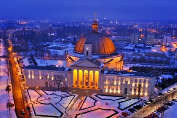 Obraz premium Aerial winter view of illuminated basilica at blue hour in Lichen Stary, Poland