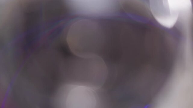 Defocused lens shine. Round glow. White purple light circle rotate on gray abstract background. Bright gradient color flash blur tunnel ray.