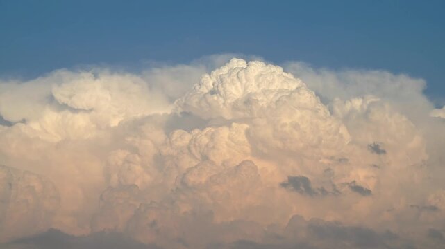 Cumulonimbus cloud developing and rising dramatically due to strong updrafts, captured in a cinematic timelapse. The structure resembles a volcanic plume in the atmosphere.