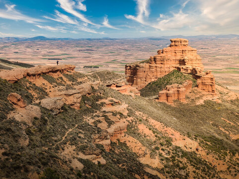 Hiker overlooking dramatic red rock landscape in Spain, Sierra de Armantes, panoramic arid mountains