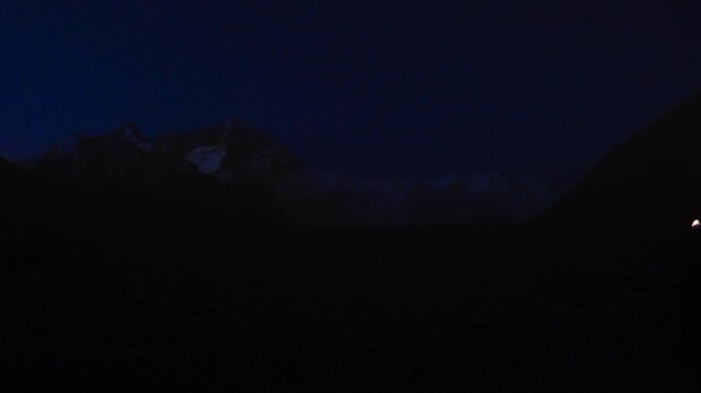 Group of climbers with headlamps walking in a row in the dark on Mount Everest