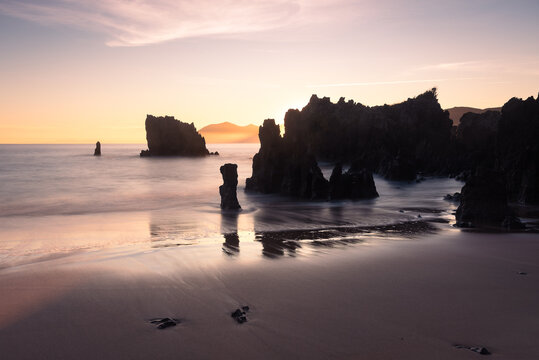 Beautiful long exposure scenic view of the rocky coastline in the Cantabrian sea at dawn, Noja, Cantabria, Spain
