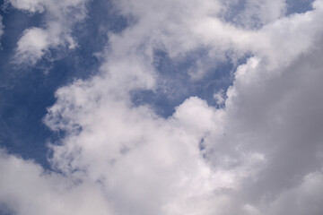 Fototapeta premium Sky filled with scattered white clouds over blue expanse