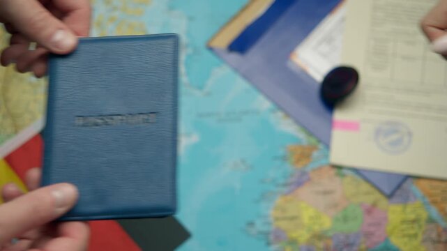 New citizen receives German passport from hands amid citizenship documents and national flags.