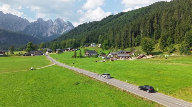 Aerial sideways tracking shot of cars driving in Gosau valley, Austria