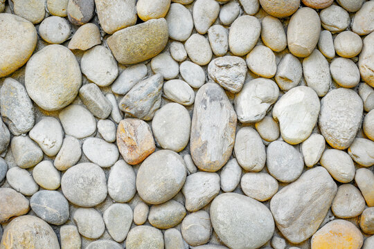 Rounded river rocks covering flat pebble surface close up