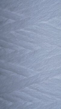 Close up of white polypropylene string wound sediment filter cartridge used for water purification filtration and household plumbing systems, rotates. Texture or background polypropylene water filter