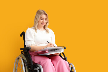 Young businesswoman with office folder and clipboard in wheelchair on orange background