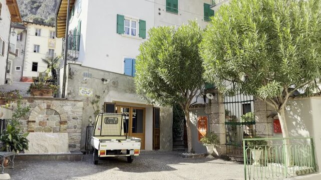 Piazzetta with Mature Olive Trees and Vintage Ape Piaggio Three-Wheeler in Historic Village of Limone sul Garda, Lake Garda, Italy