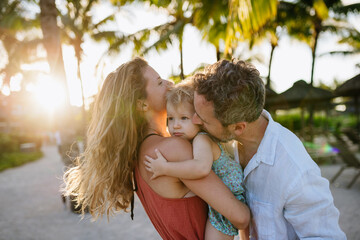 Fototapeta premium Parents with little toddler in tropical beach resort.