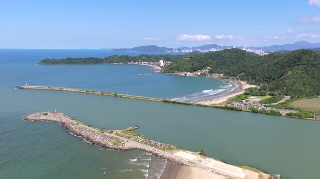 Aerial view of Navegantes lighthouse and Itajai breakwater marking harbor entrance and maritime navigation channel.