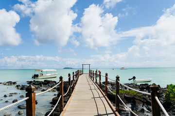 Obraz premium Tropical beach jetty in Mauritius resort with turquoise sea and sky.