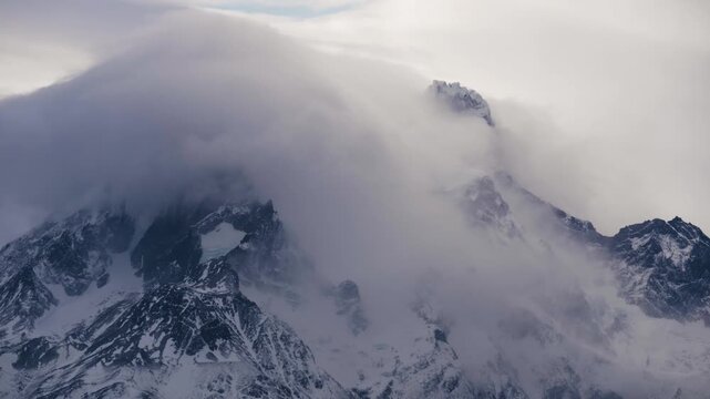 4K video; timelapse of clouds moving over a snow covered mountain peak, Torres del Paine National Park, Chile