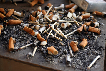 Niedopałki papierosów na parapecie przy oknie © arteffect.pl