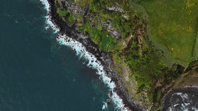 Aerial view of green-covered volcanic cliffs along Atlantic coast of Sao Miguel Island, Azores, Portugal