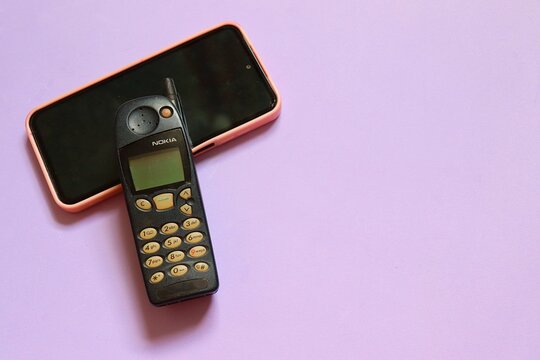 Salvador, Brazil - March 26, 2026: A classic Nokia 5120 cellular phone is displayed alongside a modern smartphone, showcasing the evolution of mobile technology. 