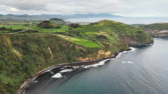 Aerial view of rural agricultural landscape on rugged volcanic coastline in Azores, Portugal.