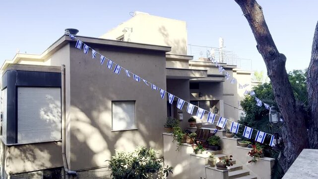 villa view with Israeli flags among pine trees in sunny weather