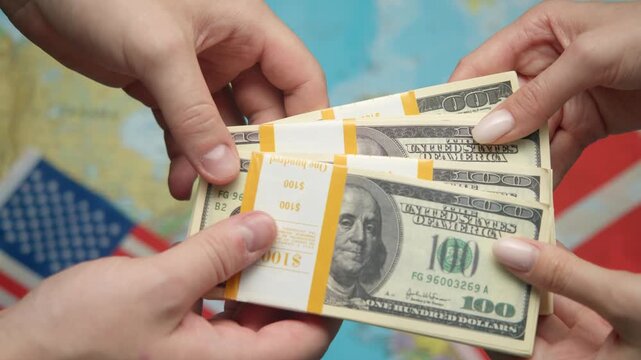American diplomat passes stack of dollars to Danish partner against world map with US and Danish flags for strengthening economic ties.